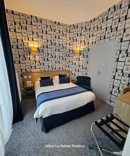 a hotel room with a bed and a wall at Hôtel Le Rohan Charme et Caractère in Pontivy