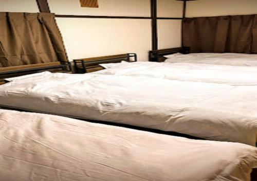 two beds in a bedroom with white sheets at M,AP - Vacation STAY 16056 in Otaru