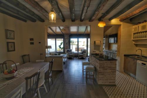 a kitchen and living room with a table and chairs at Casa de Vivar a 5 minutos de Puy du Fou in Cobisa