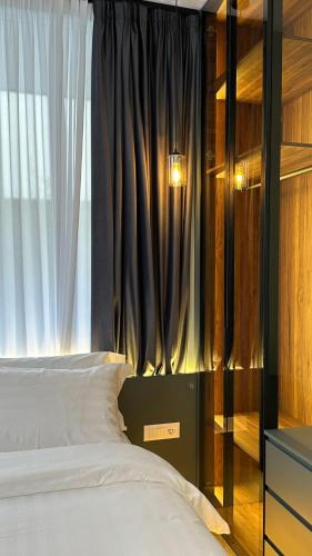 a bedroom with a bed with a large window at Tirana Central Rooms in Tirana