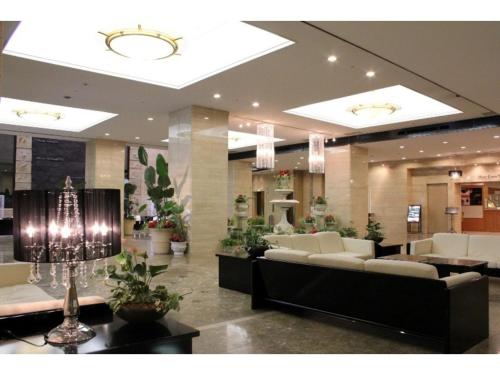 un vestíbulo con sofás blancos y plantas en un edificio en Hotel Nagoya Garden Palace - Vacation STAY 25775v, en Nagoya