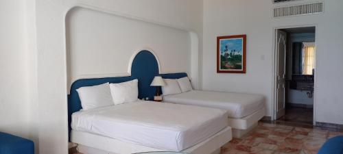 a hotel room with two beds and a window at Hotel & Museo Casa Turquesa in Cancún