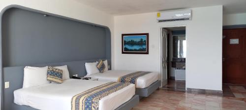 a hotel room with two beds and a mirror at Hotel & Museo Casa Turquesa in Cancún