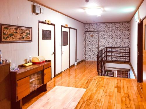 een woonkamer met een houten vloer en witte muren bij Eimiya Ryokan - Vacation STAY 36263v in Amakusa