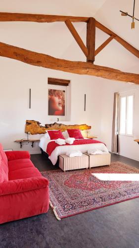 - une chambre avec un grand lit et un canapé rouge dans l'établissement Chambres d'Hôtes Doux Brazil, à Lisle-sur-Tarn