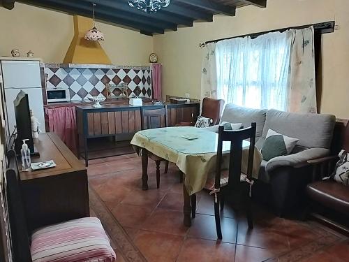 ein Wohnzimmer mit einem Sofa und einem Tisch in der Unterkunft Casa Rural Josefina 1 y 2 in Navaconcejo