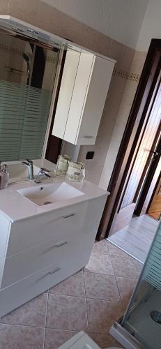 uma casa de banho com um lavatório branco e um espelho. em Daniela's Home em Selvino