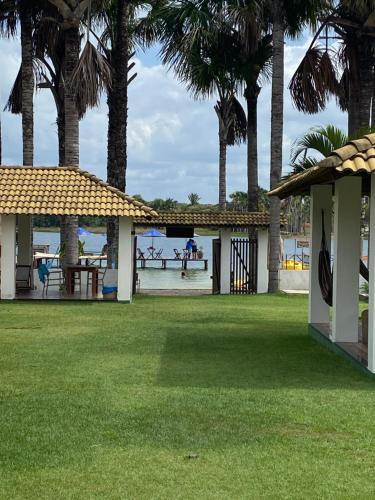 a view of a park with palm trees and a pier at Lagoa do Cassó - Pousada Porto do Cajú in Caçozinho