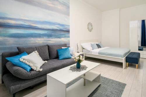 a living room with a couch and a bed at 2 real beds, AC by the Central Market Hall in Budapest