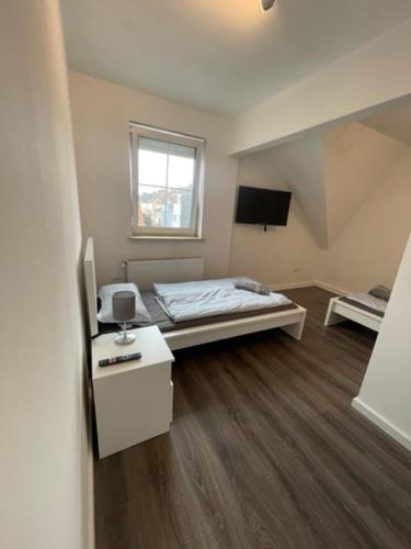 Schlafzimmer mit einem Bett, einem Schreibtisch und einem TV in der Unterkunft MonteurHaus Am Airport in Bremen