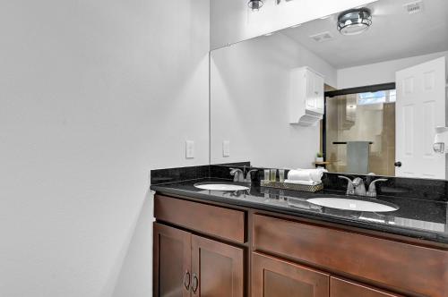 Un baño con dos lavabos y un espejo grande. en *Heart of Houston* Pet friendly/14ppl/4br/2.5b, en Houston