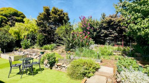 un giardino con tavolo e sedie in erba di The Garden Cottage a Tawonga