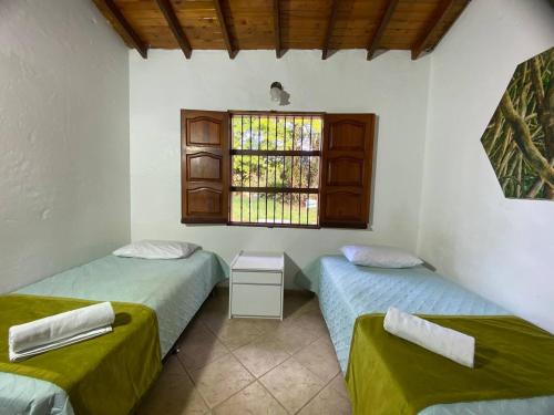 two beds in a room with a window at EL FAUNO in Jericó