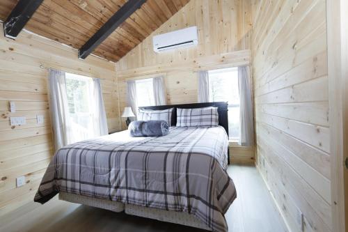 1 dormitorio con 1 cama en una pared de madera en Matterhorns Hunter Lodge en Hunter