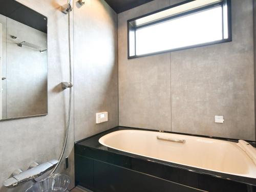 a bathroom with a bath tub and a window at Seagull east coast Awaji - Vacation STAY 21943v in Awaji