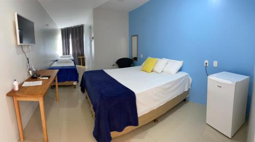 a bedroom with a bed and a desk and a television at Lagoa do Cassó - Pousada Porto do Cajú in Caçozinho