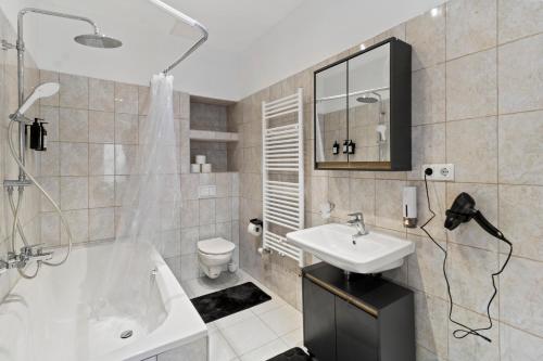 a bathroom with a sink and a tub and a toilet at Coy Apartments Vienna #1 in Vienna