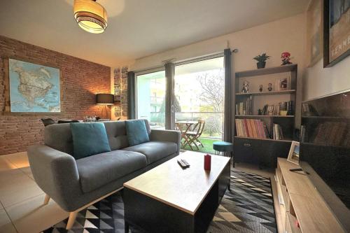 sala de estar con sofá y mesa de centro en L'Odyssée-Appart au calme avec balcon et parking en Nantes