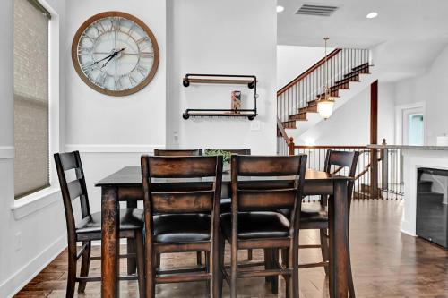 a dining room table with chairs and a clock on the wall at Relax in HTX POOL,15ppl,4br,4b in Houston