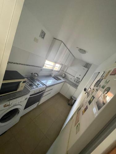 a small kitchen with a stove and a refrigerator at HERMOSO DEPARTAMENTO AMUEBLADO EN EL CENTRO DE LP in La Plata