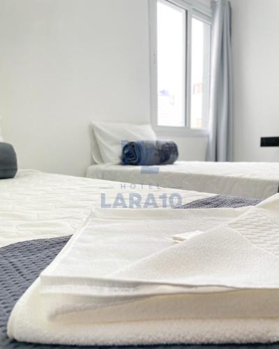 two beds in a room with a hotel la palapa sign on them at Hotel Lara 10 Curitiba in Curitiba