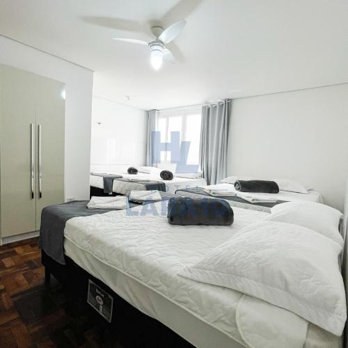 a group of beds in a room with a ceiling fan at Hotel Lara 10 Curitiba in Curitiba