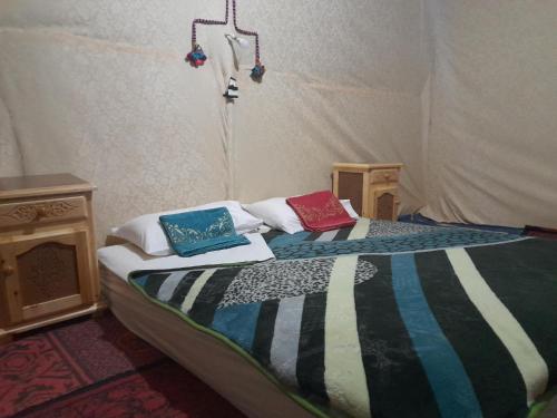 a bed in a tent with two pillows on it at RestCamp ErgChebbi in Merzouga