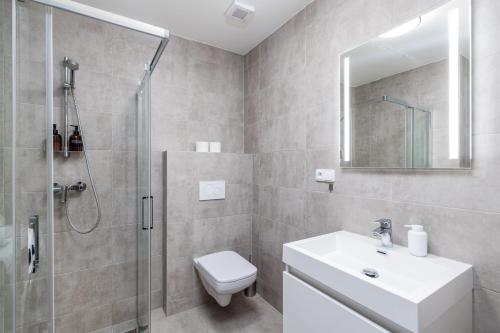 een badkamer met een douche, een toilet en een wastafel bij Apartment Cimburkova in Praag