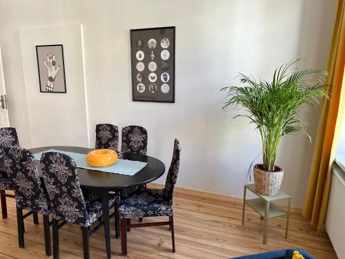 a dining room with a table and chairs and a plant at Apartament Trzecie Piętro in Poznań