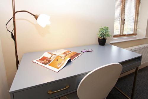 an office desk with a book and glasses on it at St Julians Place in Shrewsbury