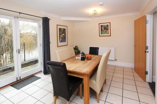 a dining room with a wooden table and chairs at St Julians Place in Shrewsbury