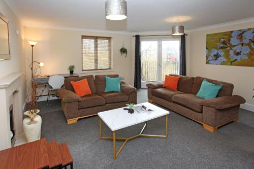 a living room with two couches and a table at St Julians Place in Shrewsbury