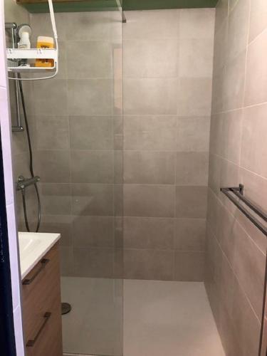 une douche avec une porte vitrée dans une salle de bain dans l'établissement Appartement donnant sur le port de plaisance de Port Camargue et a proximité des plages, au Grau-du-Roi