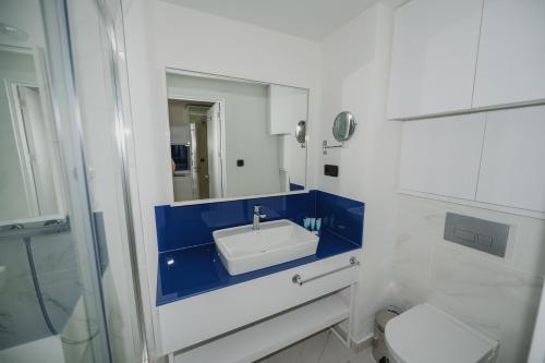 a white bathroom with a sink and a toilet at Twin Towers Orbi City Batumi in Batumi