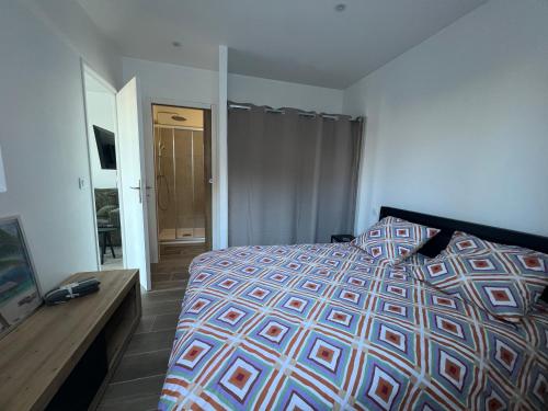 Un dormitorio con una cama y un televisor. en maison t2 avec jaccuzi wifi parking, en Saint-Cyr-sur-Mer