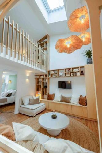 - un salon avec un escalier et une table dans une pièce dans l'établissement ღ Mezzanine • T4 Spacieux, Lumineux et Cosy, à La Rochelle