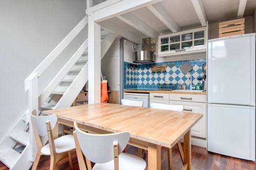 une cuisine avec une table en bois et des appareils électroménagers blancs dans l'établissement T3 cosy , cœur historique de La Rochelle, à La Rochelle