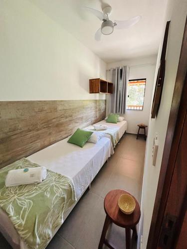 two beds in a room with two tables at Casa Passarinho - Vale do Capão in Vale do Capao