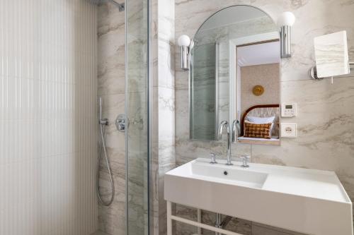 a bathroom with a sink and a shower at Hotel des Carmes by Malone in Paris
