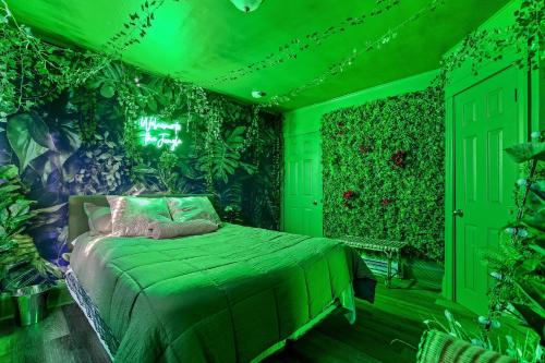 1 dormitorio verde con 1 cama con plantas en las paredes en TheHottieHouse: Fun Fantasy Experience Apt On Blvd, en Filadelfia