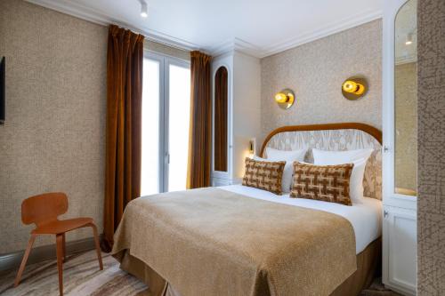 a hotel room with a bed and a window at Hotel des Carmes by Malone in Paris