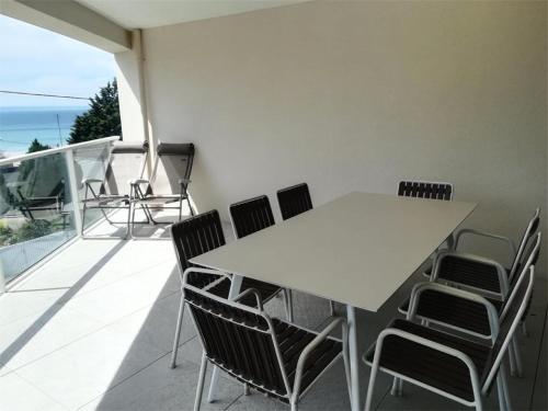 a white table and chairs on a balcony with the ocean at Résidence Coteau - Charmant appartement de 70m² dans une résidence à deux pas de la plage. MAE-6584 in Pléneuf-Val-André