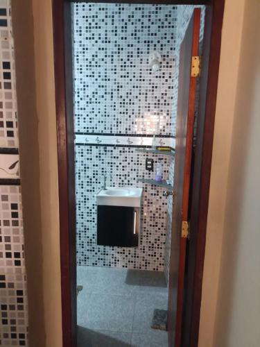 a bathroom with a sink and a tiled wall at Casa prox a praia de itapua in Salvador