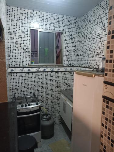 una cocina con azulejos blancos y negros en la pared en Casa prox a praia de itapua, en Salvador