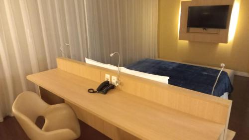 a room with a desk with a chair and a tv at ###SENSACIONAL### MERCURE APART HOTEL PREMIUM in Manaus