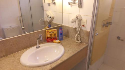 um balcão de casa de banho com um lavatório e um telefone em ###SENSACIONAL### MERCURE APART HOTEL PREMIUM em Manaus