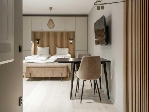 um quarto com uma cama, uma mesa e cadeiras em Slopeside Serenity in Are Ski-in Ski-out Studio em Åre