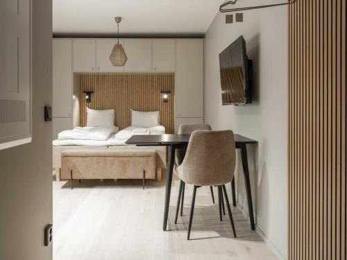 a bedroom with a bed and a table and chairs at Slopeside Serenity in Are Ski-in Ski-out Studio in Åre