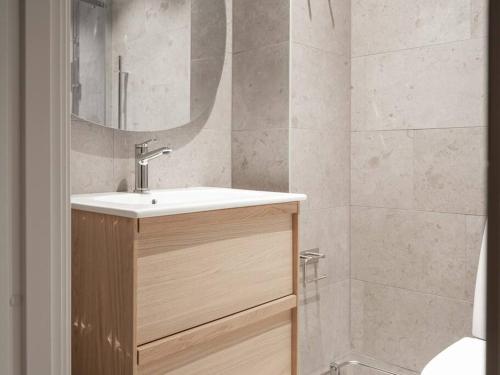 uma casa de banho com um lavatório e um chuveiro com um espelho. em Slopeside Serenity in Are Ski-in Ski-out Studio em Åre