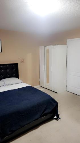 um quarto com uma cama grande e um closet em Cozy jets empire em Brampton